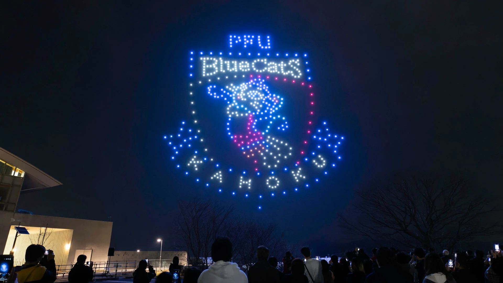 夜空にドローンがPPU Blue Cats KAMOKUのロゴマークとキャラクターを形成