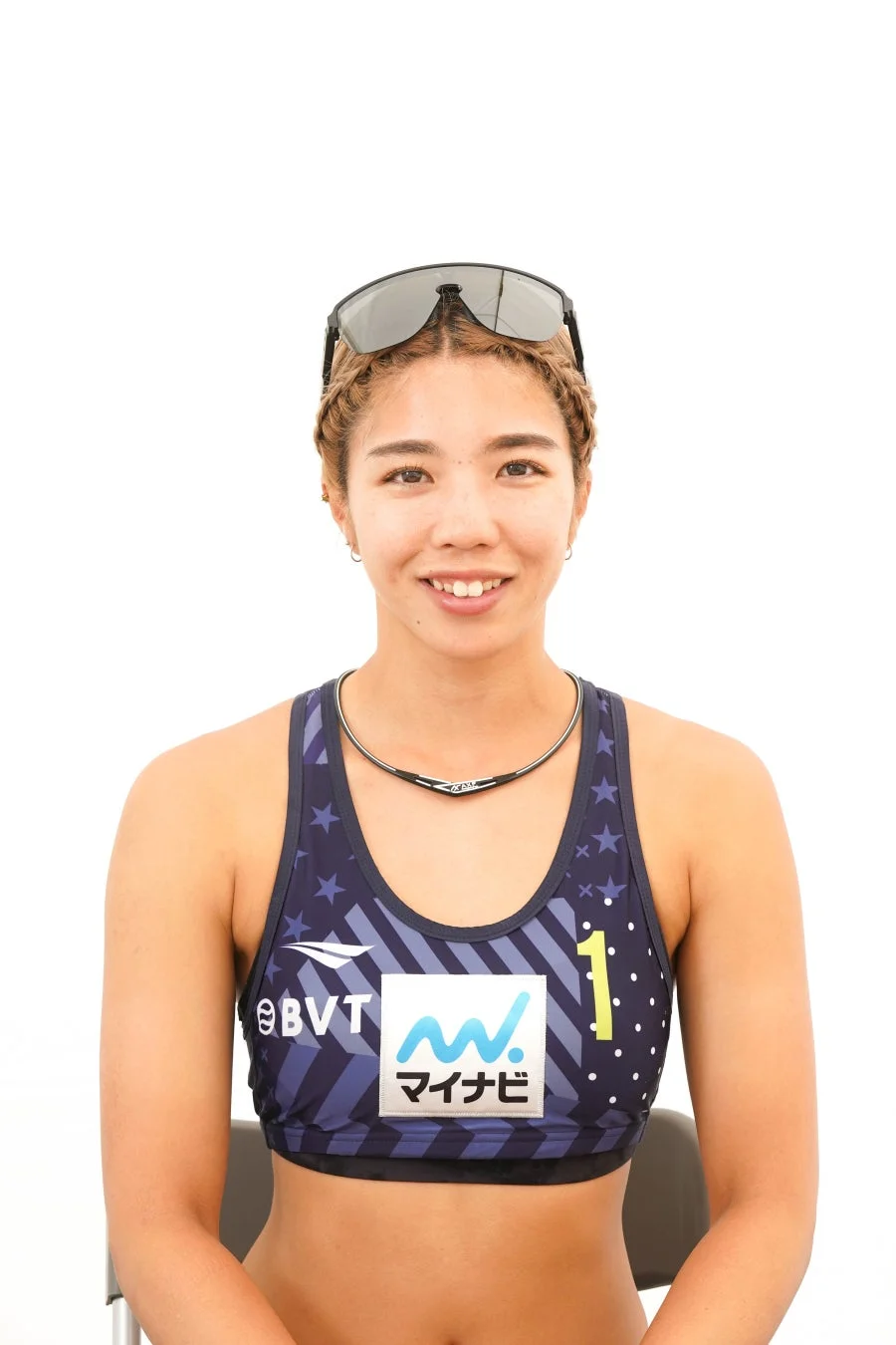 白い背景の前で笑顔を見せる女性アスリートのポートレート