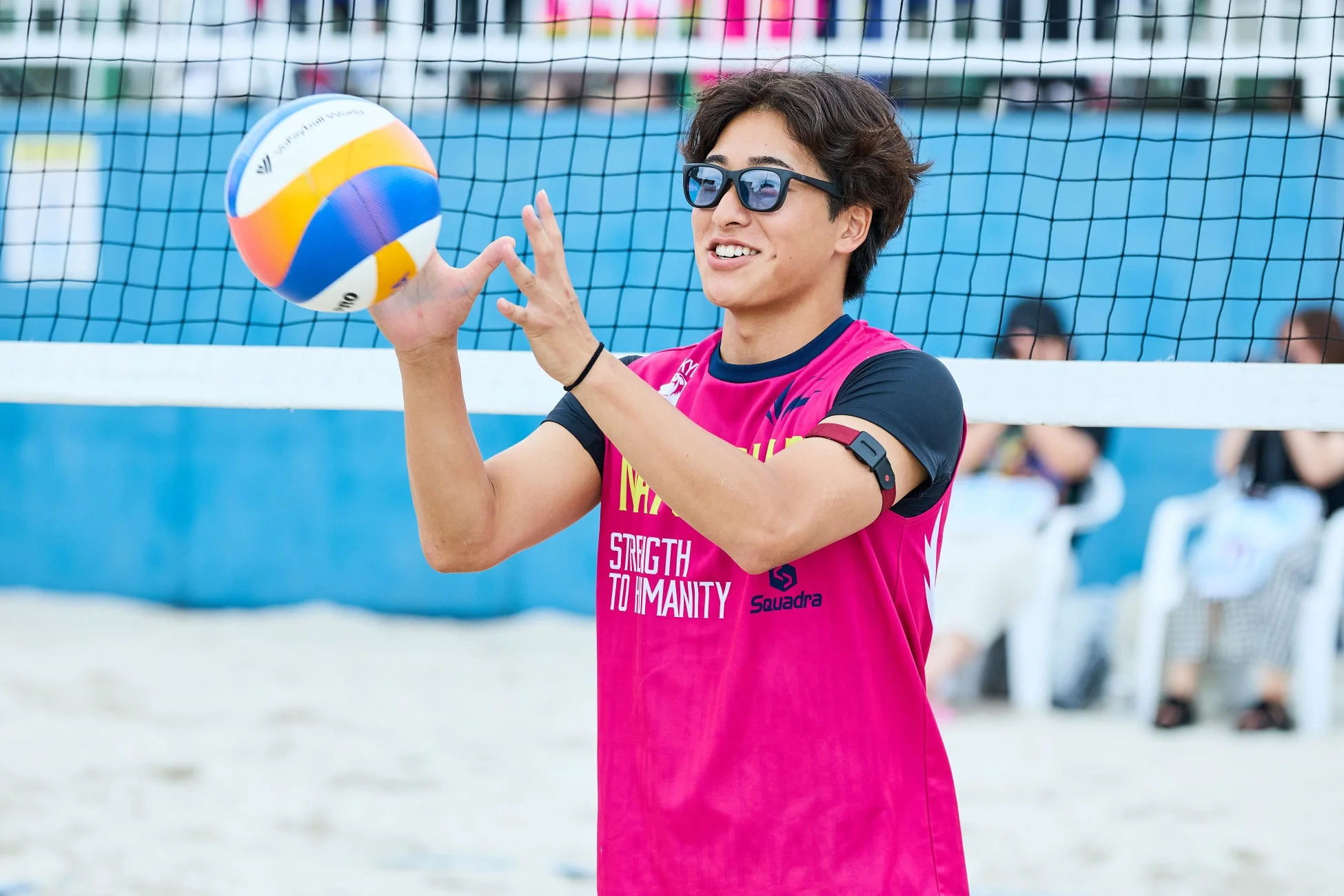 ビーチバレーボールの試合中に笑顔を見せる若い男性選手