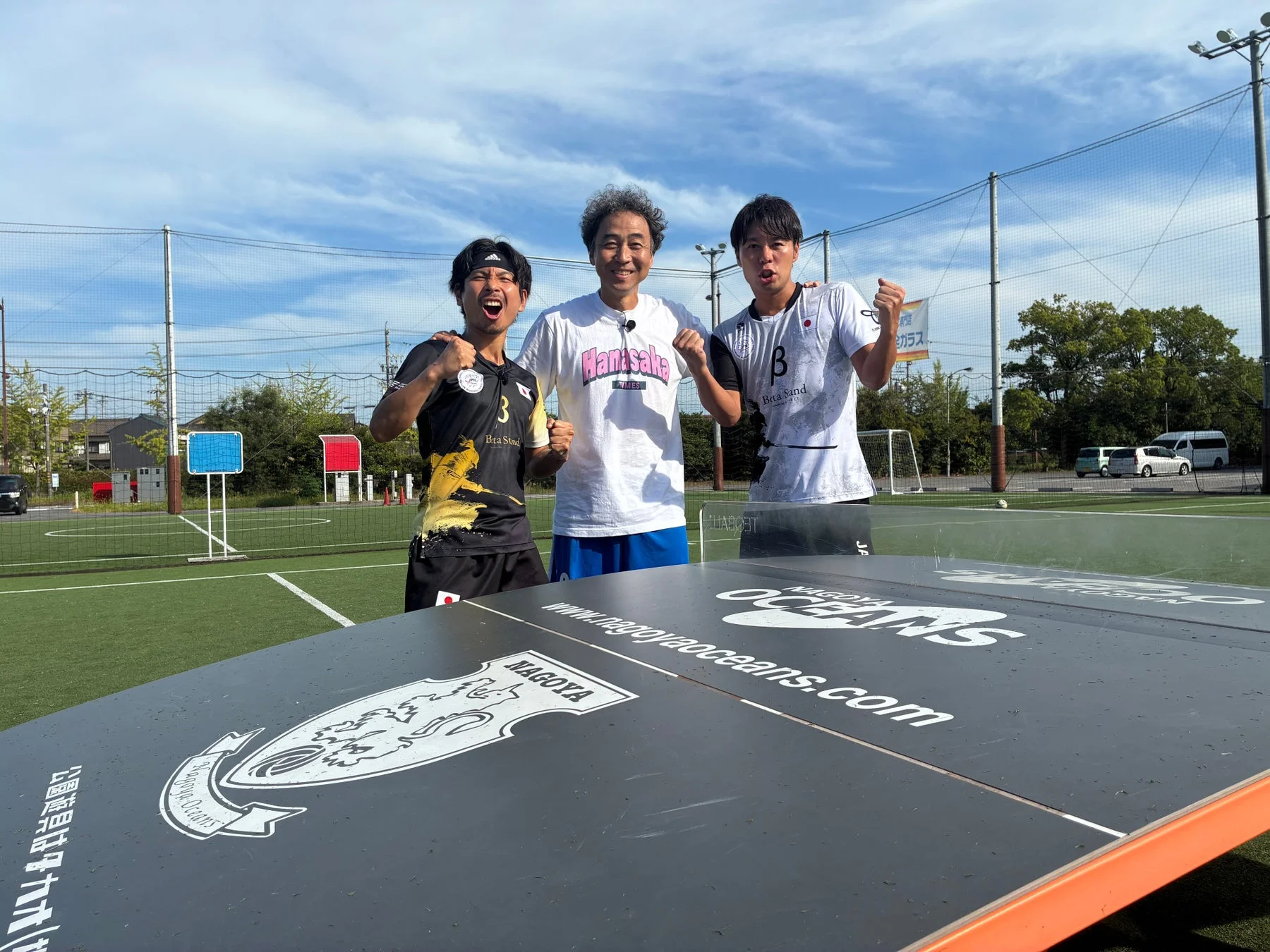 フットサルコートでガッツポーズをする男性たち