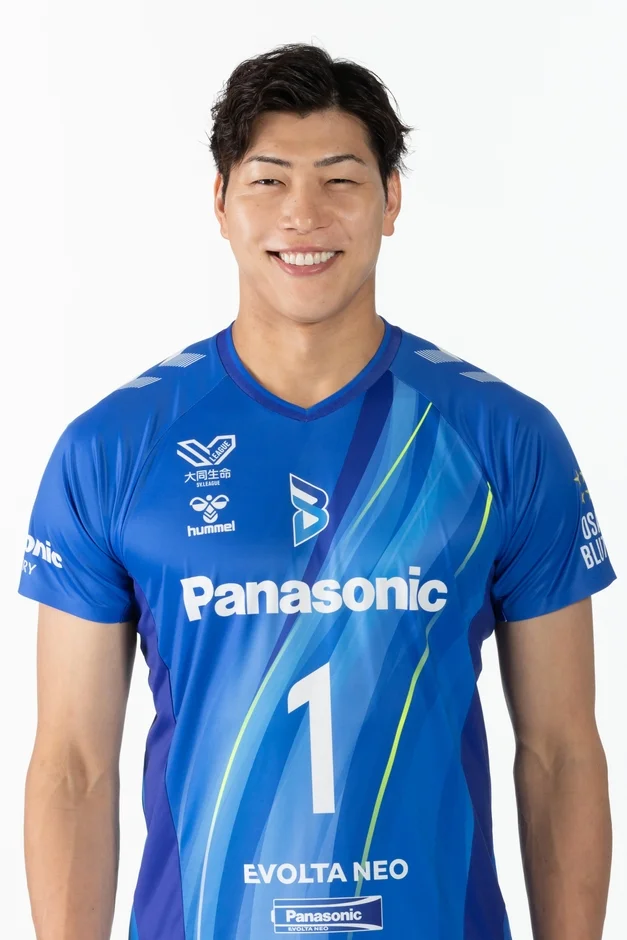 青いパナソニックのユニフォームを着て笑顔でカメラを見つめる男性アスリートのポートレートです。ユニフォームにはV.LEAGUE、大同生命、hummel、EVOLTA NEOなどのロゴと背番号1が確認できます。